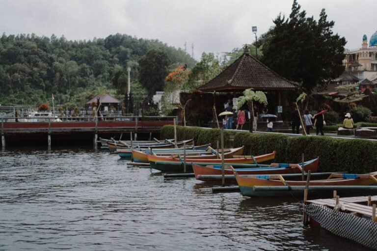 Colorful canoes docked on a peaceful lake with people exploring the scenic environment.